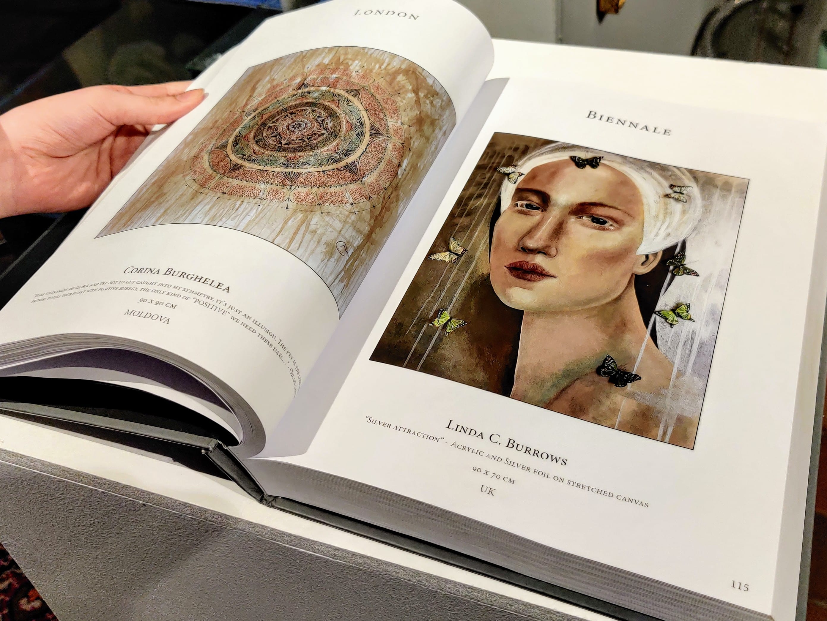The Biennale catalogue lying open, a spread of exhibited works across both pages.