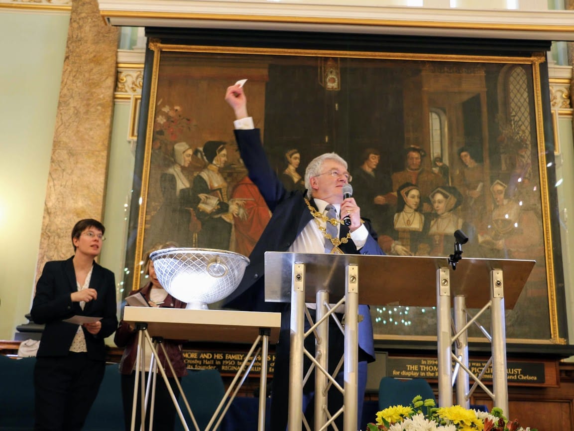Councillor Will Pascall, Mayor of Kensington and Chelsea, drawing the winning charity raffle ticket.